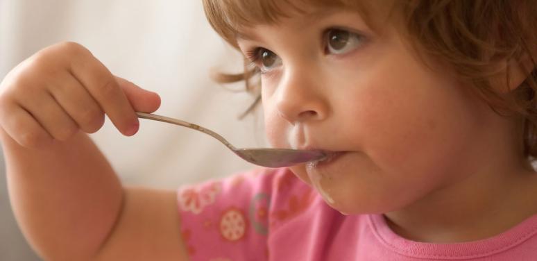 child feeding herself